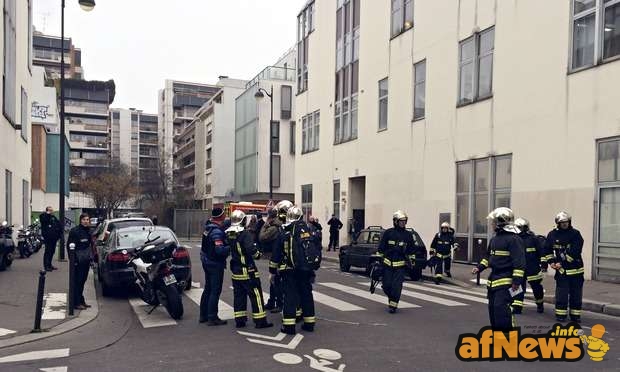 Police and firefighters gather in front of the offices of Charlie Hebdo in Paris